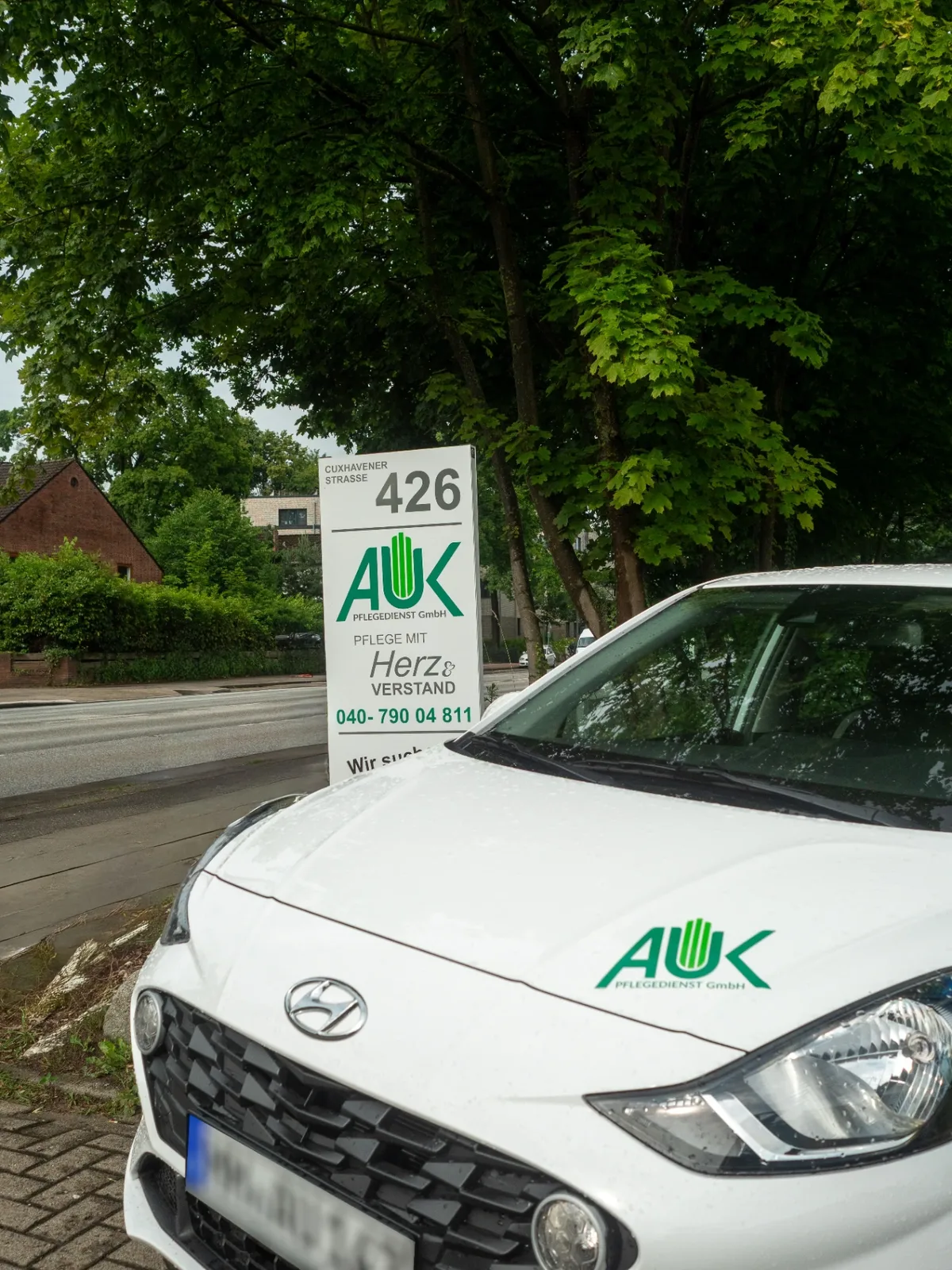 Firmenschild von AUK Pflegedienst an der Cuxhavener Straße 426 in Hamburg mit Dienstwagen